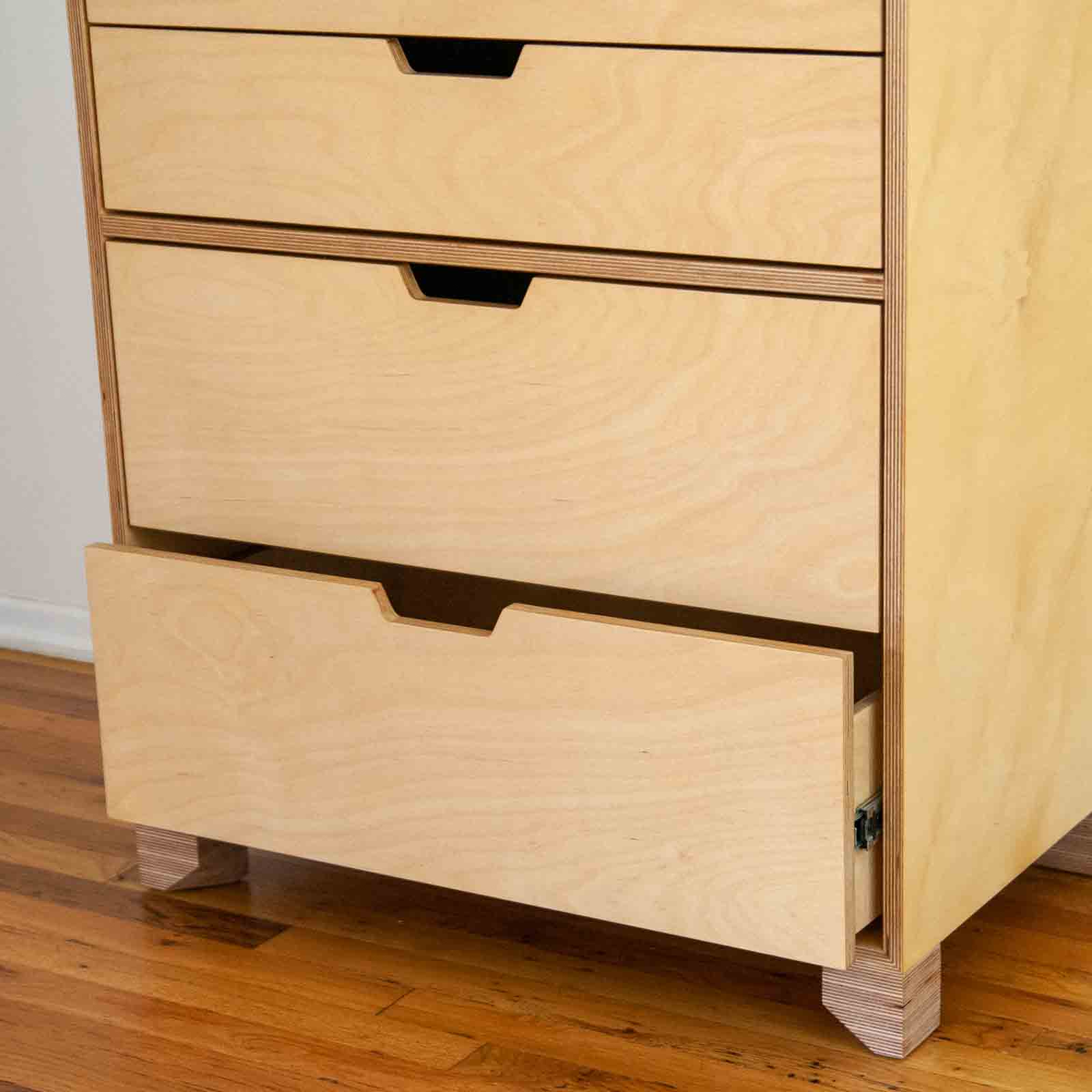 Off-angle photo of dresser with bottom drawer ajar