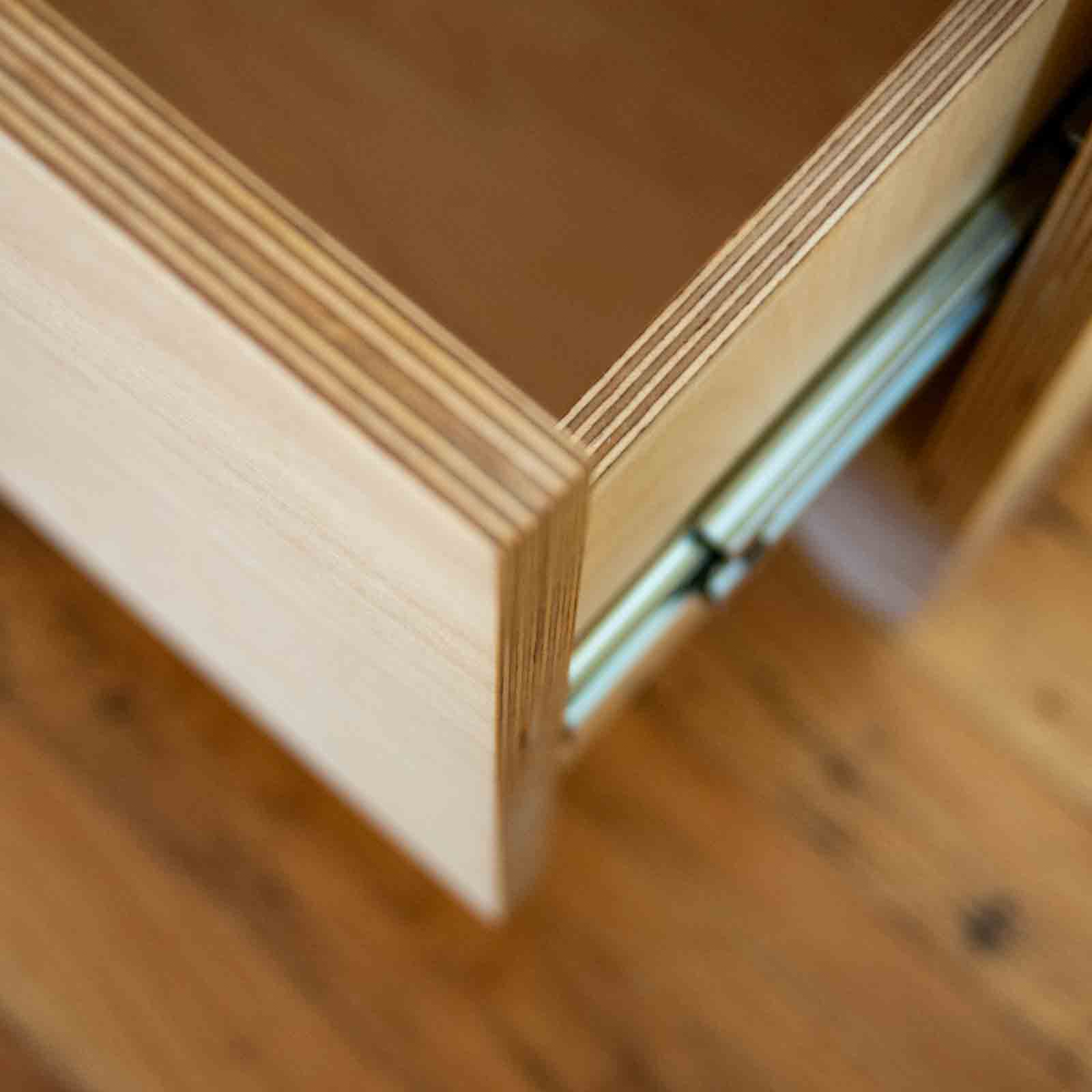 Detail photo of opened empty dresser drawer showing interior build and drawer slides